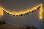 string with led , with a small clip attached the poloroid photos on a wall, the led is attached to the string not to the clip , give a long shot(panaromic) on a wall
